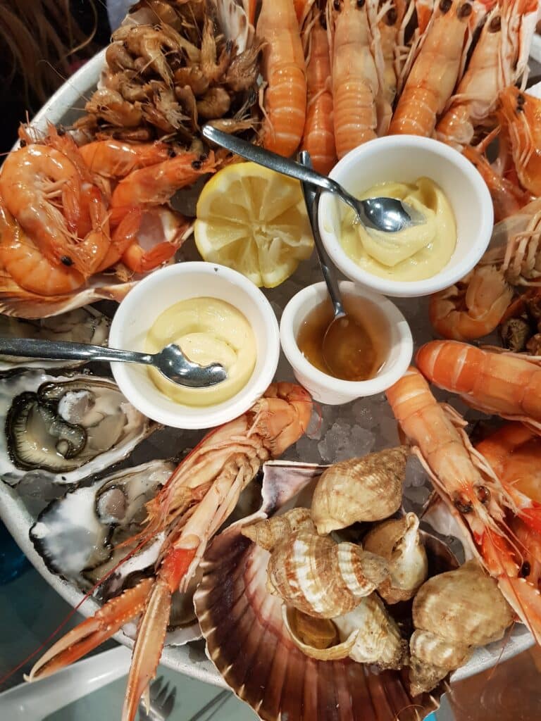 Plateau de fruits de mer glacé : huîtres, langoustines, crevettes, bigorneaux, avec citron et sauces. Assortiment frais.